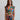 Woman wearing a colorful patterned set against a plain background